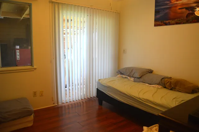 a bedroom with a bed and wooden floor