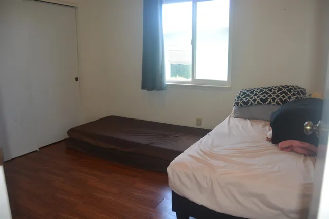 a bed sitting in a bedroom next to a window