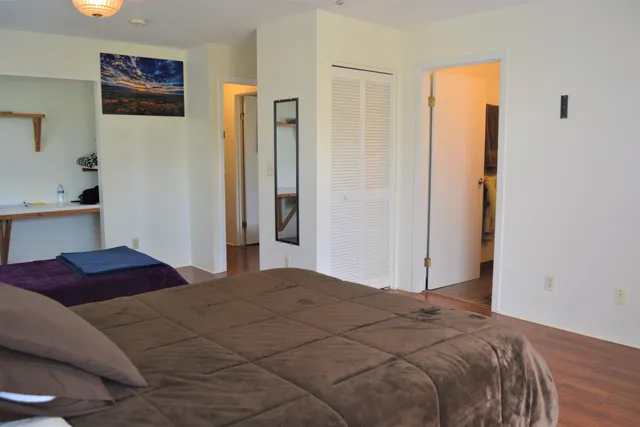 a bedroom with a bed and a refrigerator