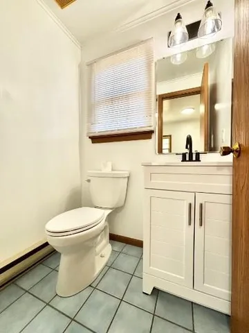 a bathroom with a granite countertop toilet sink and mirror