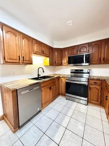 a kitchen with granite countertop a stove sink and cabinets