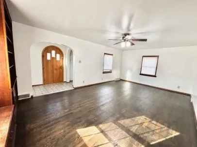 a view of a livingroom with wooden floor and a ceiling fan
