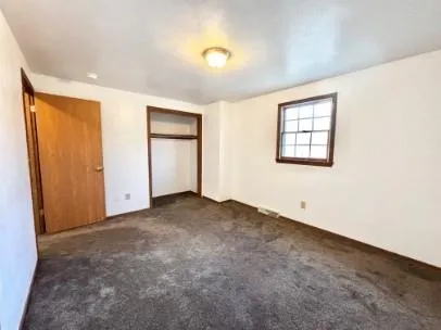 an empty room with windows and closet