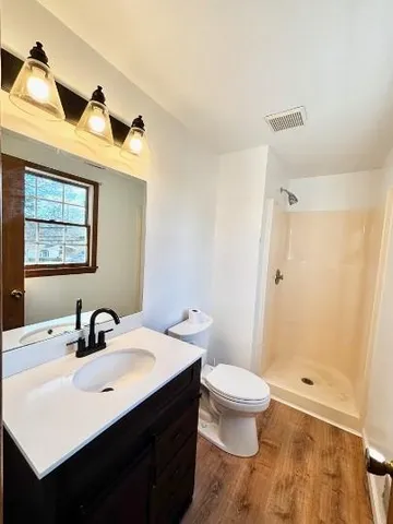 a bathroom with a sink a toilet and shower