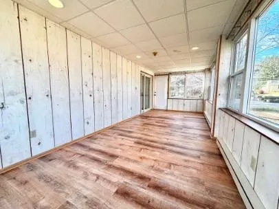 a view of a bedroom with wooden floor and windows