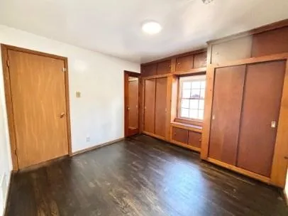 an empty room with wooden floor and a window