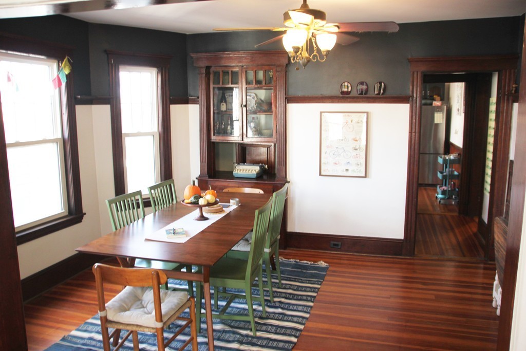 80 Aldrich Street, Unit 2 Boston, MA 02131 - Photo 5 of 20 a dining room with wooden floor a chandelier a wooden table and chairs