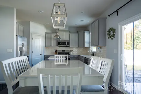 a view of a dining room with furniture a chandelier and wooden floor