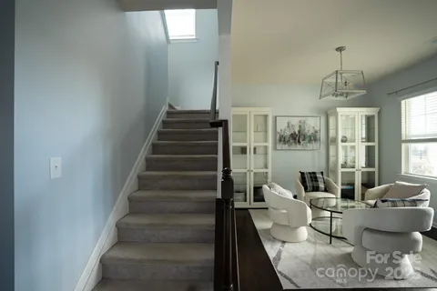 a living room with furniture and a chandelier