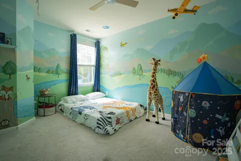 a bedroom with a bed window and wall painting