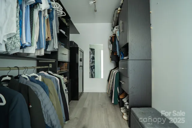 a view of walk in closet with clothes and shoes
