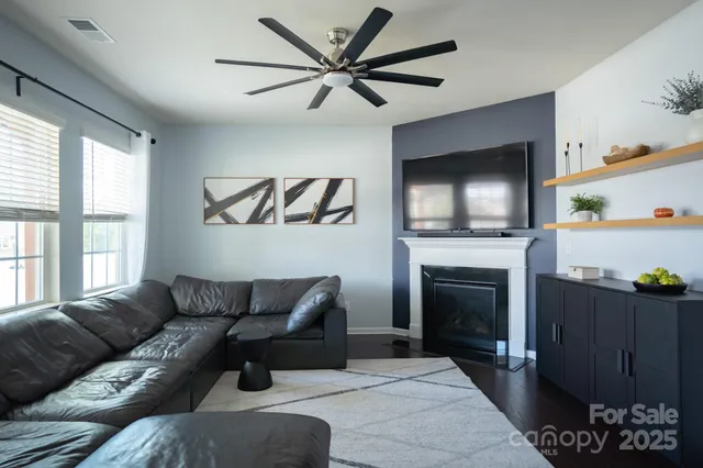 a living room with furniture a flat screen tv and a fireplace