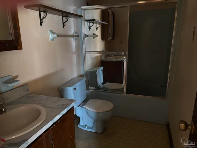 a bathroom with a granite countertop toilet and a sink