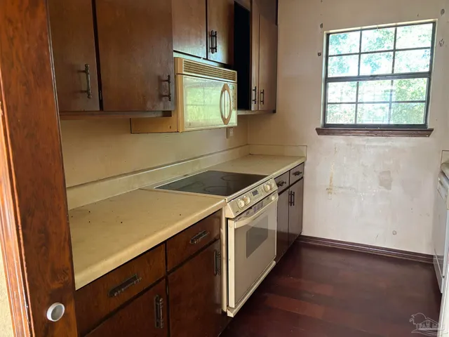 a utility room with wooden floor washer and dryer