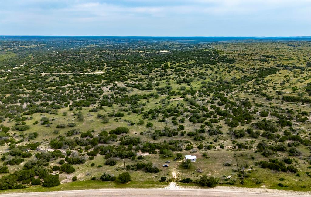an aerial view of a houses with a yard and mountain view