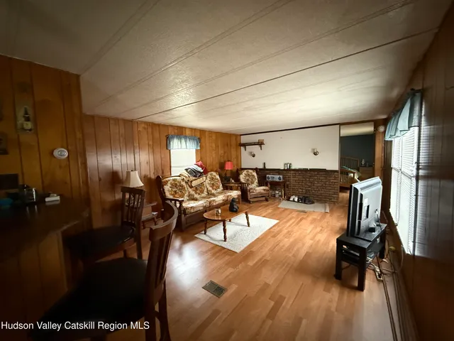 a view of a room with gym equipment and wooden floor