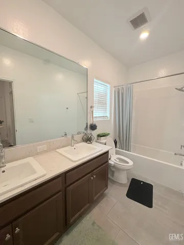 a bathroom with a double vanity sink toilet and shower