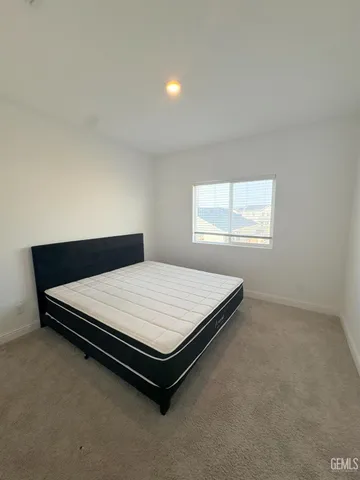 a bed sitting in a bedroom next to a window