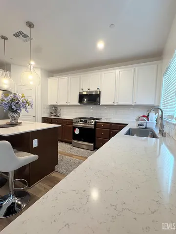 a kitchen with a sink a stove a microwave and cabinets