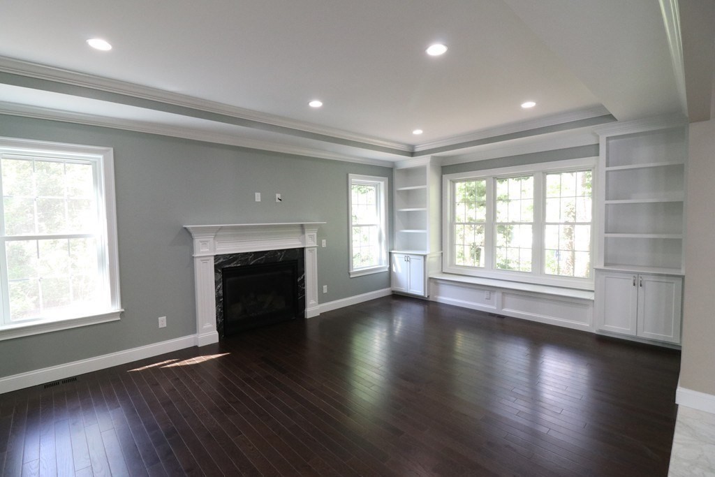5 West River Street Upton, MA 01568 - Photo 11 of 37 an empty room with wooden floor fireplace and windows