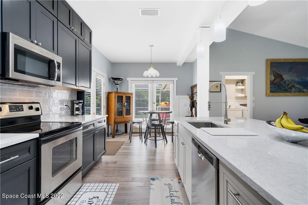 Undisclosed Address Vero Beach, FL 32963 - Photo 15 of 36 a kitchen with stainless steel appliances granite countertop a stove top oven a sink a dining table and chairs with wooden floor