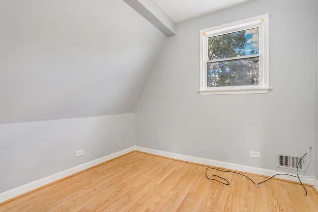 a view of a room with wooden floor and a window