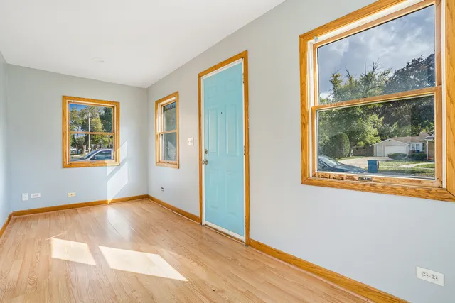 a view of a big room with wooden floor and windows