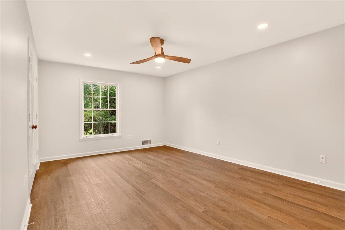 7674 Apple Valley Road Germantown, TN 38138 - Photo 12 of 15 Room featuring wood-finish flooring, recessed lighting, a ceiling fan with wooden blades, and a double-hung window with a verdant outdoor backdrop
