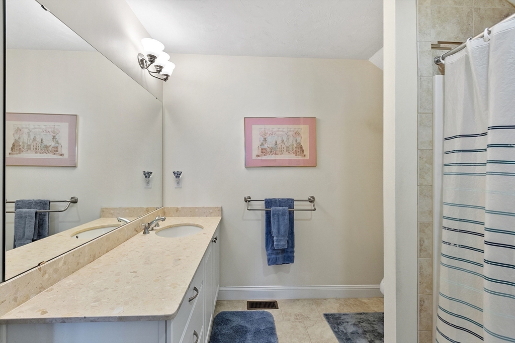 19 Marble Farm Road, Unit 19 Maynard, MA 01754 - Photo 24 of 42 a bathroom with a granite countertop sink a mirror and shower