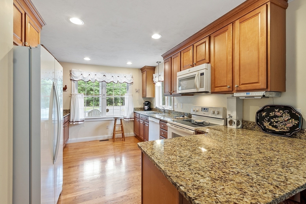 19 Marble Farm Road, Unit 19 Maynard, MA 01754 - Photo 6 of 42 a kitchen with stainless steel appliances granite countertop a stove a sink and a microwave
