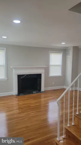 a view of empty room with wooden floor and fireplace