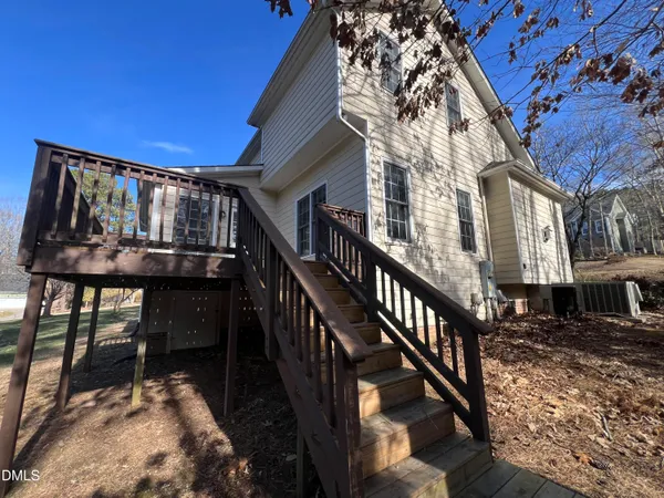 a view of a house with backyard and deck