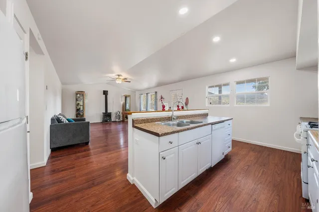 a kitchen with granite countertop a sink and wooden floor