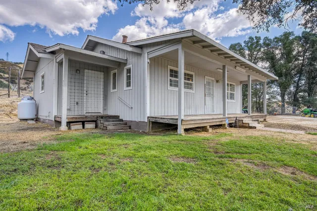 a view of a house with backyard sitting area and garden