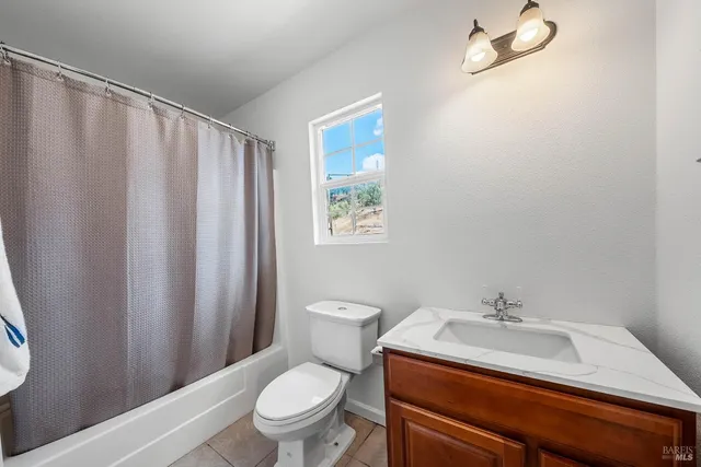 a bathroom with a sink a toilet and shower curtain