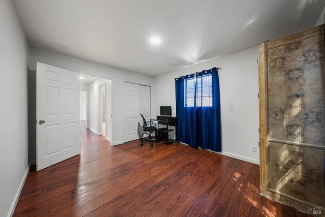 a view of a livingroom with wooden floor and a cabinet