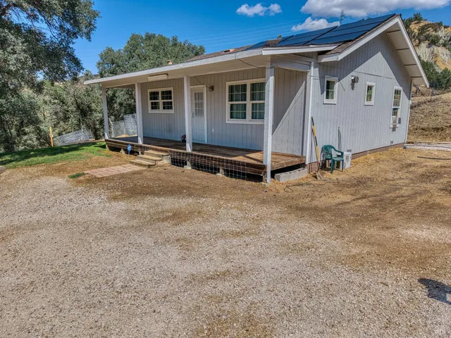 a view of a house with backyard and trees