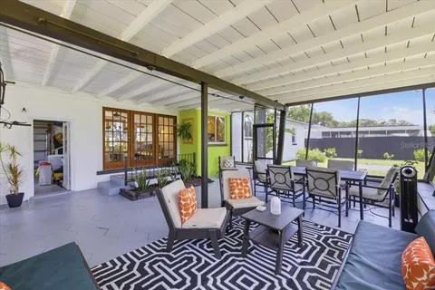 a living room with furniture large windows and wooden floor