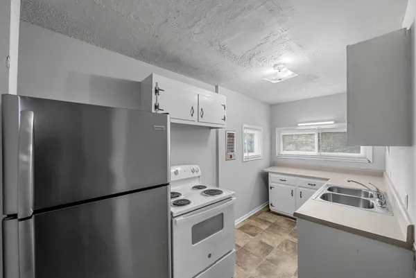 a kitchen with a refrigerator sink stove and cabinets