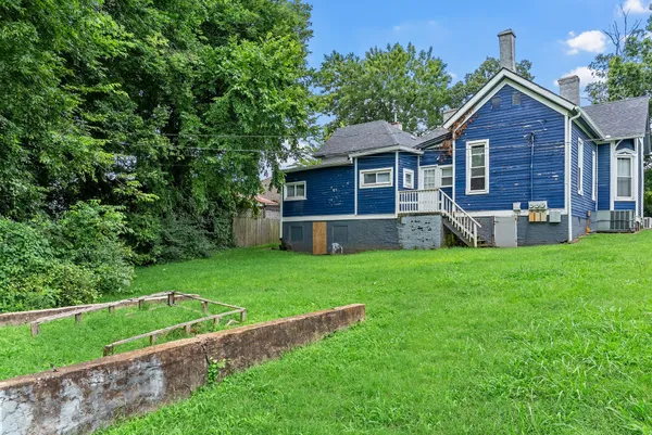 a front view of a house with a yard and green space