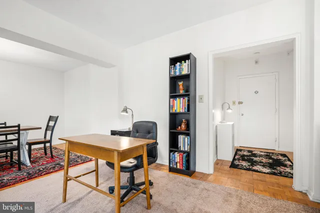 a livingroom with a workspace and a bookshelf
