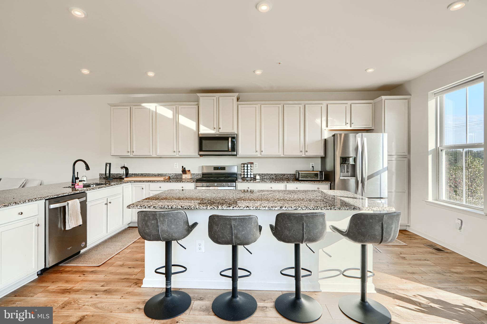 7141 Millstone Road Hanover, MD 21076 - Photo 12 of 32 a kitchen with stainless steel appliances granite countertop a table chairs sink and cabinets