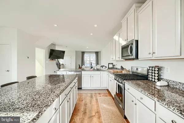 a kitchen with stainless steel appliances granite countertop a sink stove and microwave