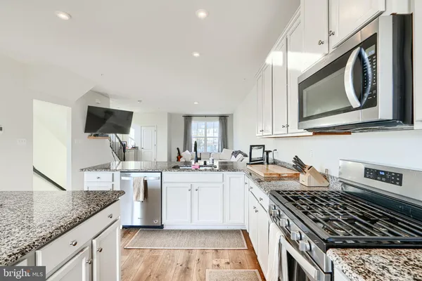a kitchen with stainless steel appliances granite countertop a stove and a sink
