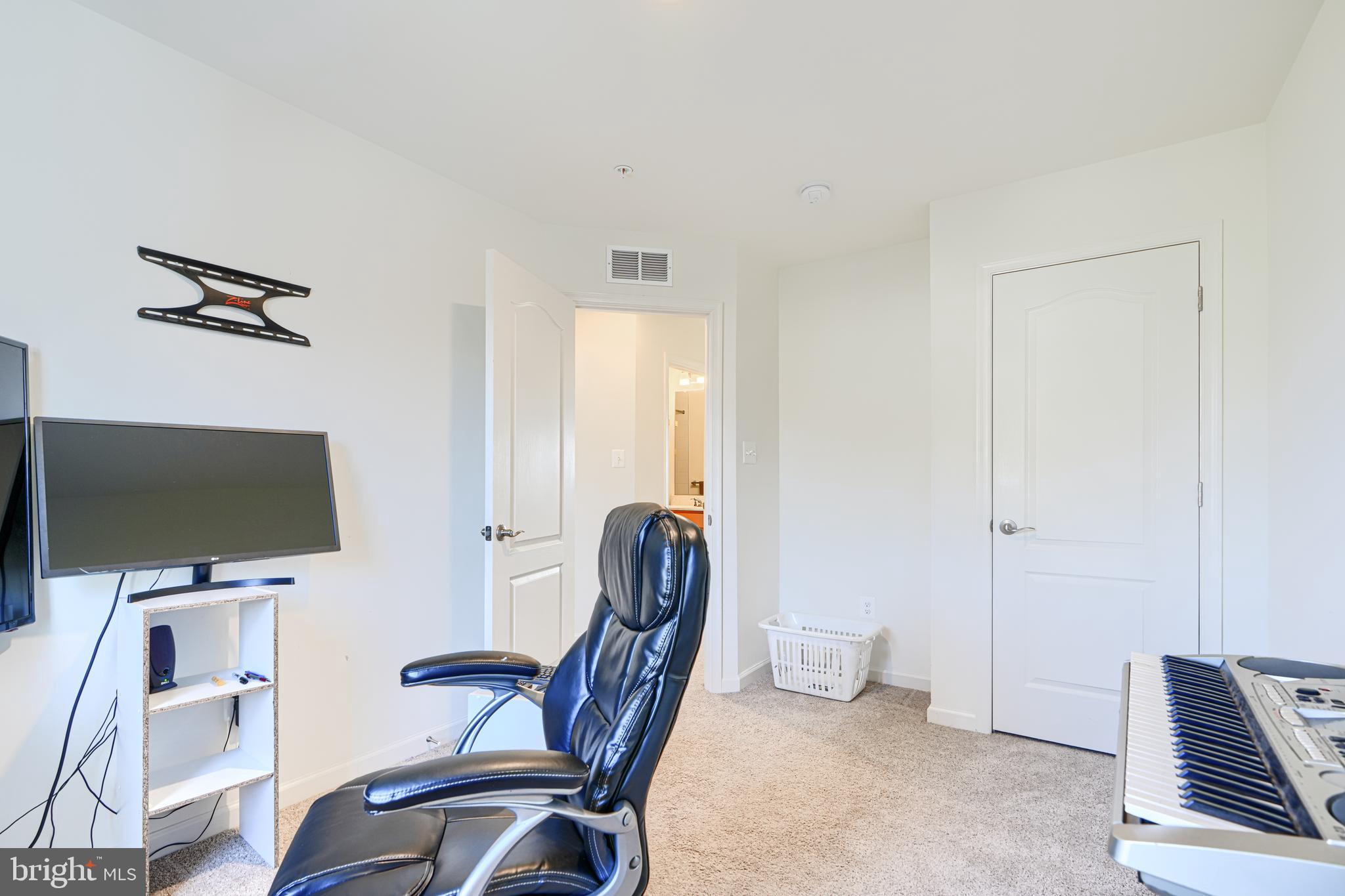 7141 Millstone Road Hanover, MD 21076 - Photo 20 of 32 a view of a workspace with furniture and a flat screen tv