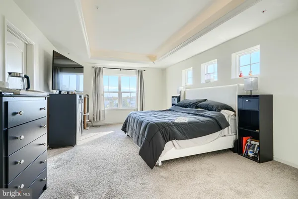 a spacious bedroom with a bed and a dresser