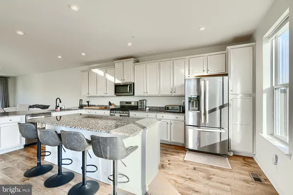 a kitchen with stainless steel appliances granite countertop a refrigerator and a stove top oven