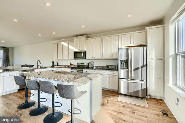 a kitchen with stainless steel appliances granite countertop a refrigerator and a stove top oven