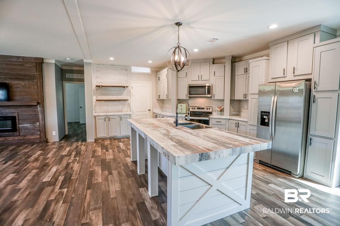 19180 Horseshoe Circle Seminole, AL 36574 - Photo 15 of 38 Kitchen with stainless steel appliances, open shelves, decorative backsplash, a center island with sink, and a chandelier