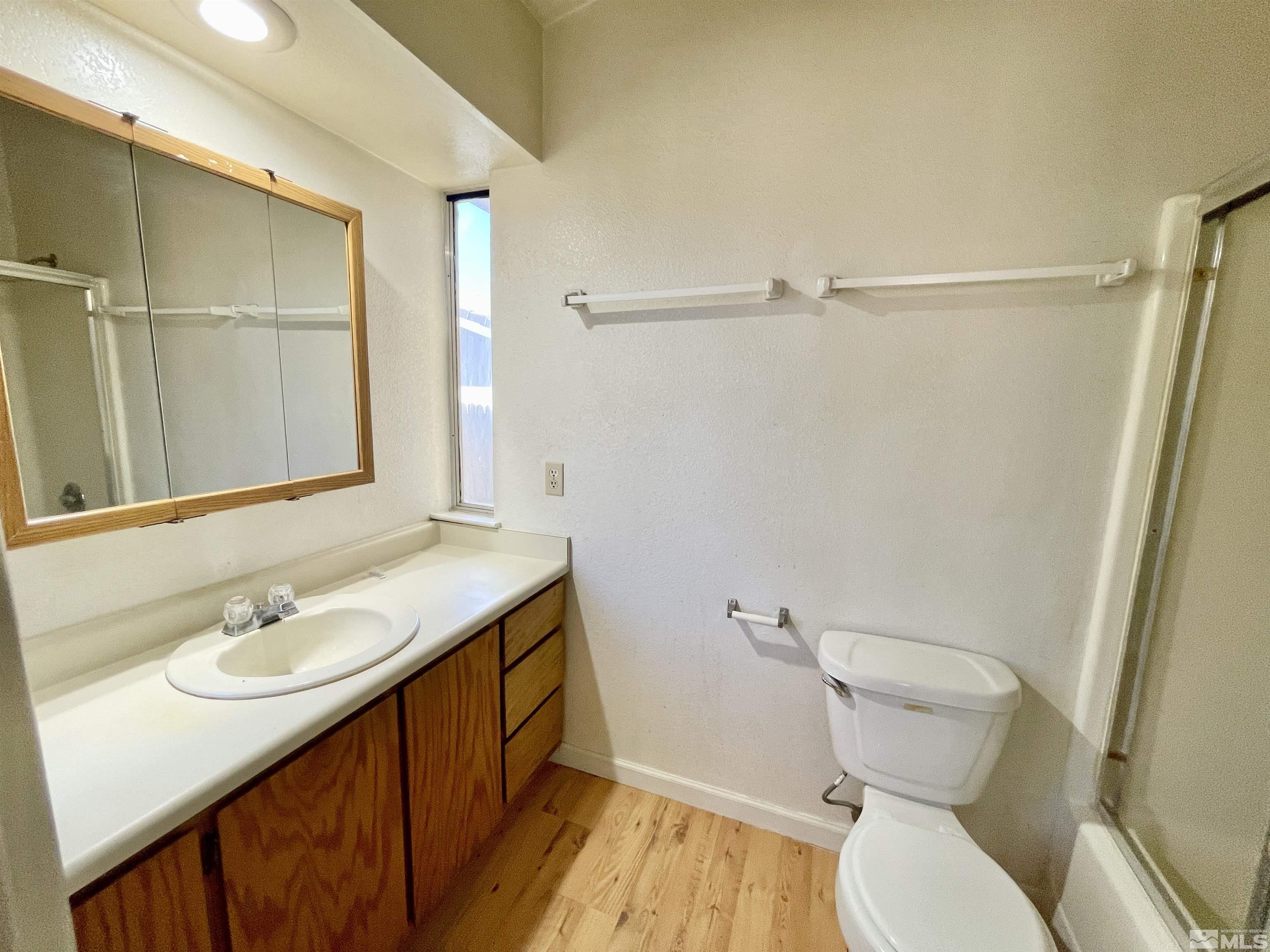 6930 Flower Street Reno, NV 89506 - Photo 10 of 19 a bathroom with a sink a toilet a mirror and shower